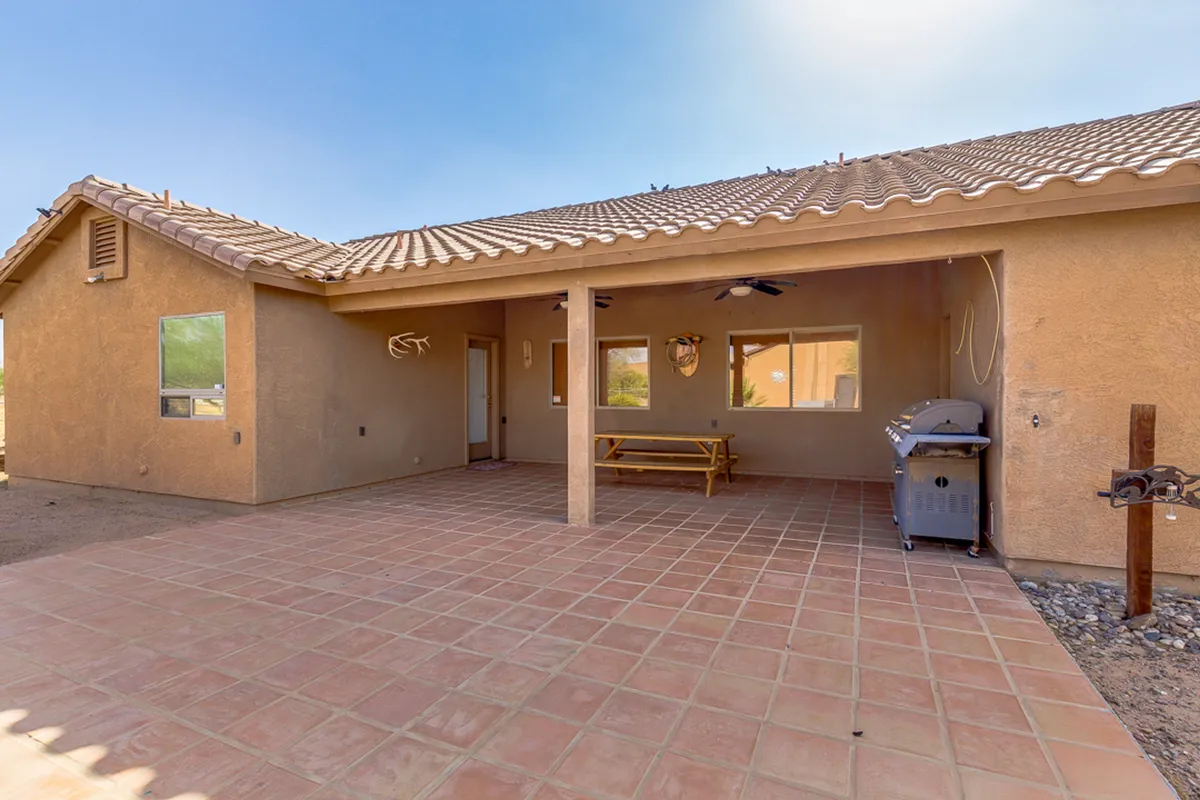 This image features a cozy outdoor seating area with a grill and large windows, suggesting a perfect space for barbecues, outdoor dining, and relaxed family gatherings. The setting is casual yet inviting, ideal for hosting group activities or enjoying peaceful moments outside.